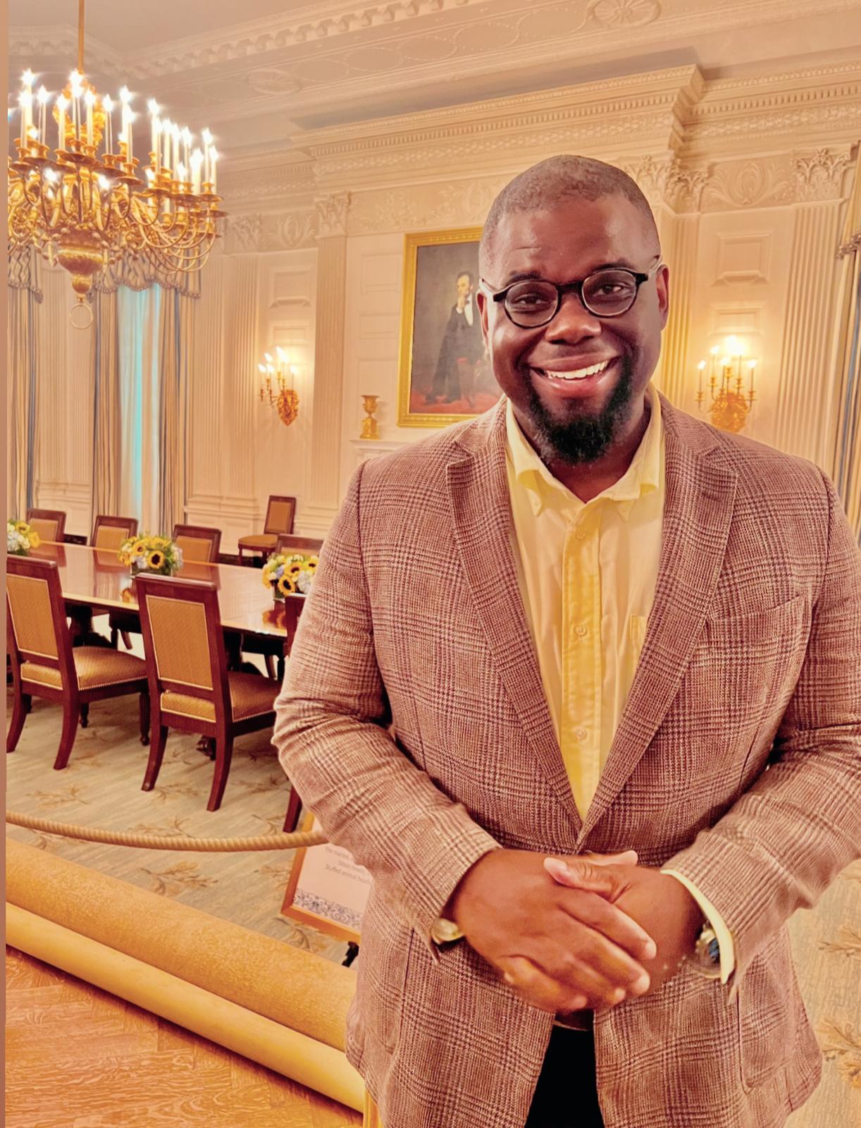 Jeremy Q. Henry standing in a formal state dining room